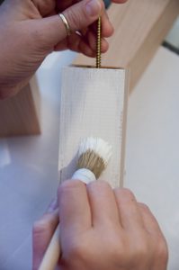 Holzstücke mit Hilfe einer langen Schraube bemalen