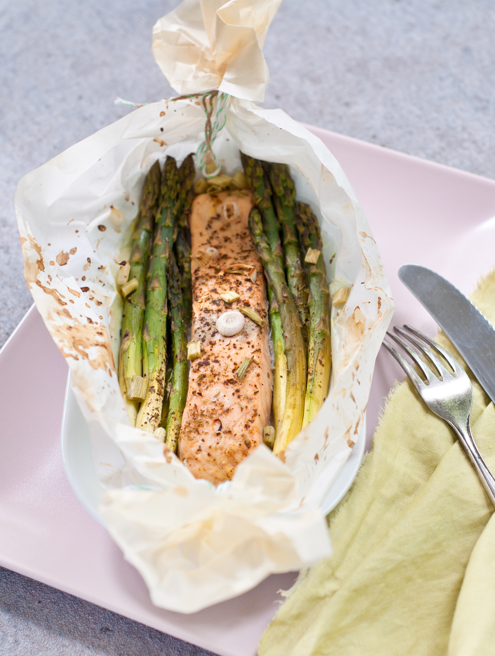 Spargel und Lachs in Butterbrotpapier aus dem Backofen