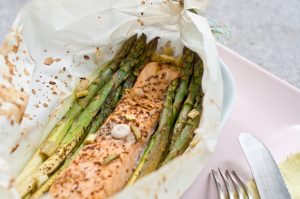 Spargel und Lachs in Butterbrotpapier aus dem Backofen