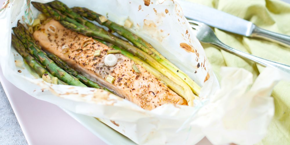 Spargel und Lachs in Butterbrotpapier aus dem Backofen