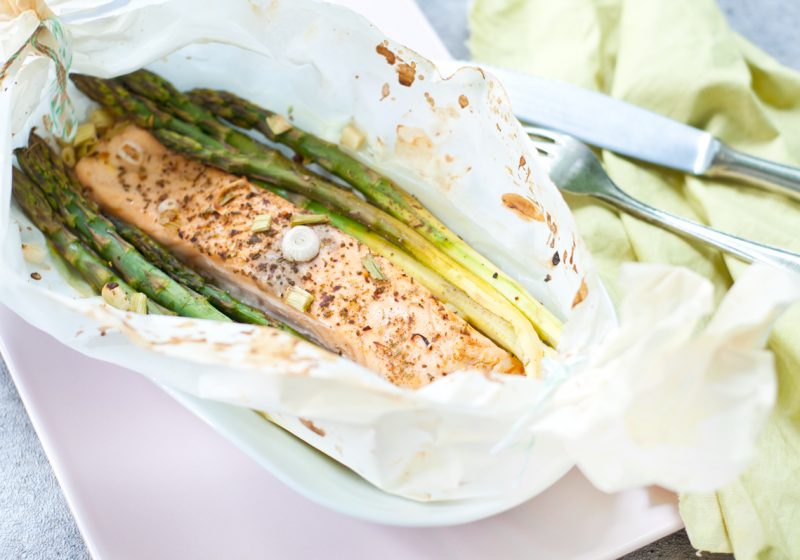 Spargel und Lachs in Butterbrotpapier aus dem Backofen