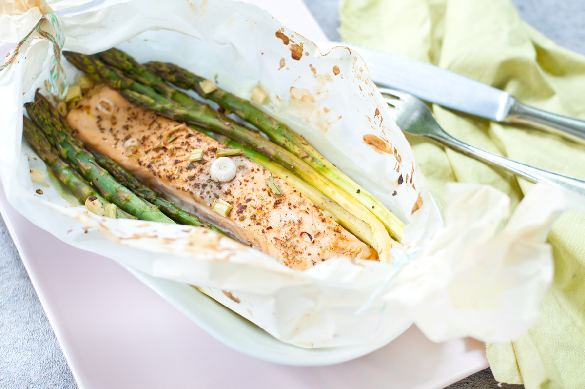 Spargel und Lachs in Butterbrotpapier aus dem Backofen