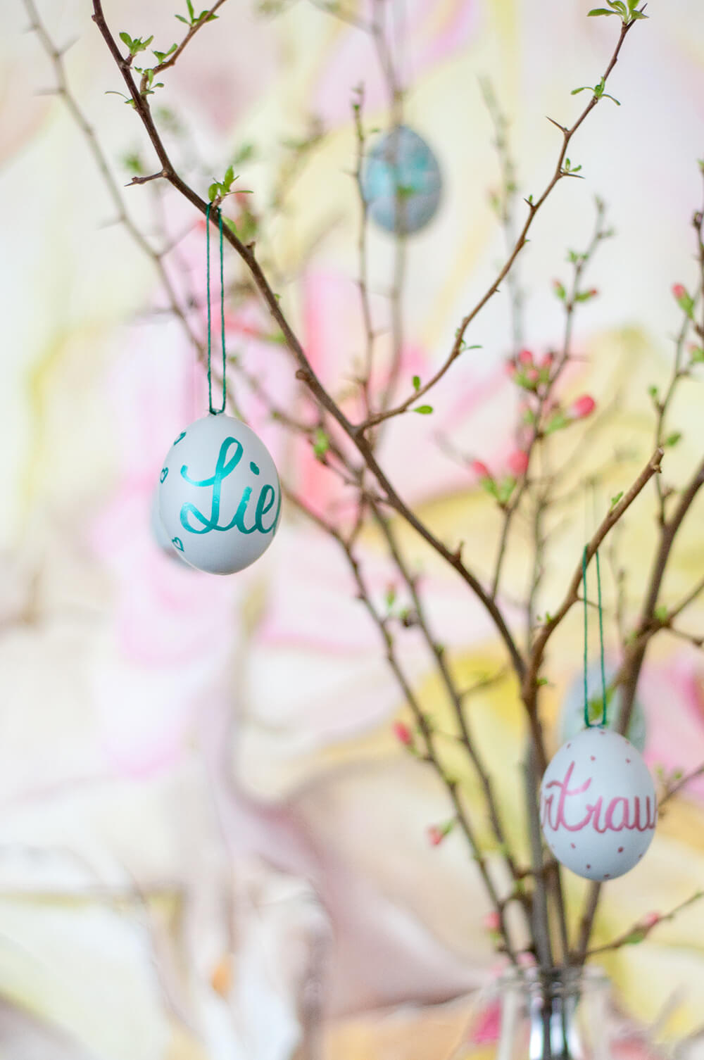 Oster-DIY selbstbemalte Eier an Quitten-Zweigen