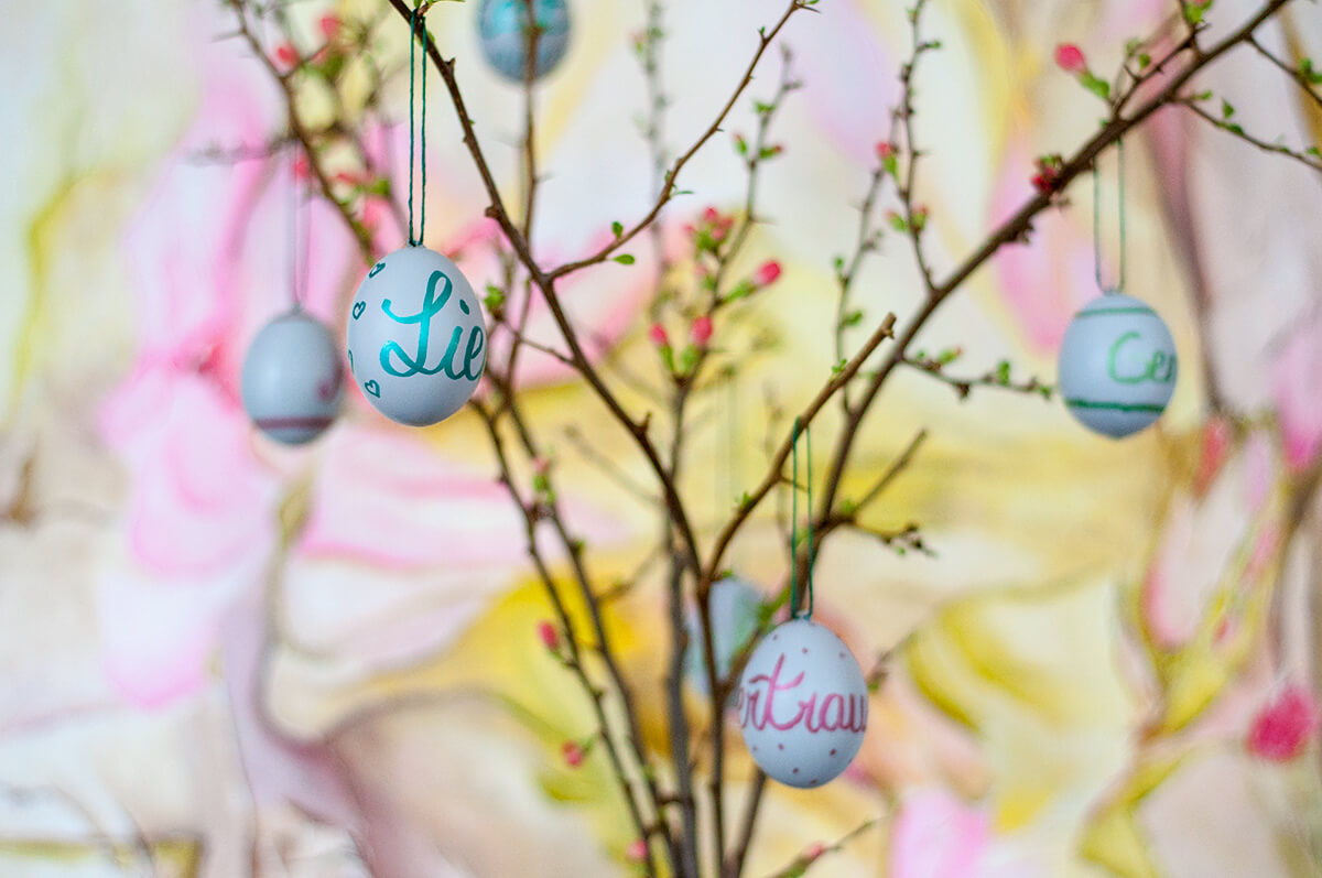 Oster-DIY selbstbemalte Eier an Quitten-Zweigen