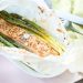 Spargel und Lachs in Butterbrotpapier aus dem Backofen